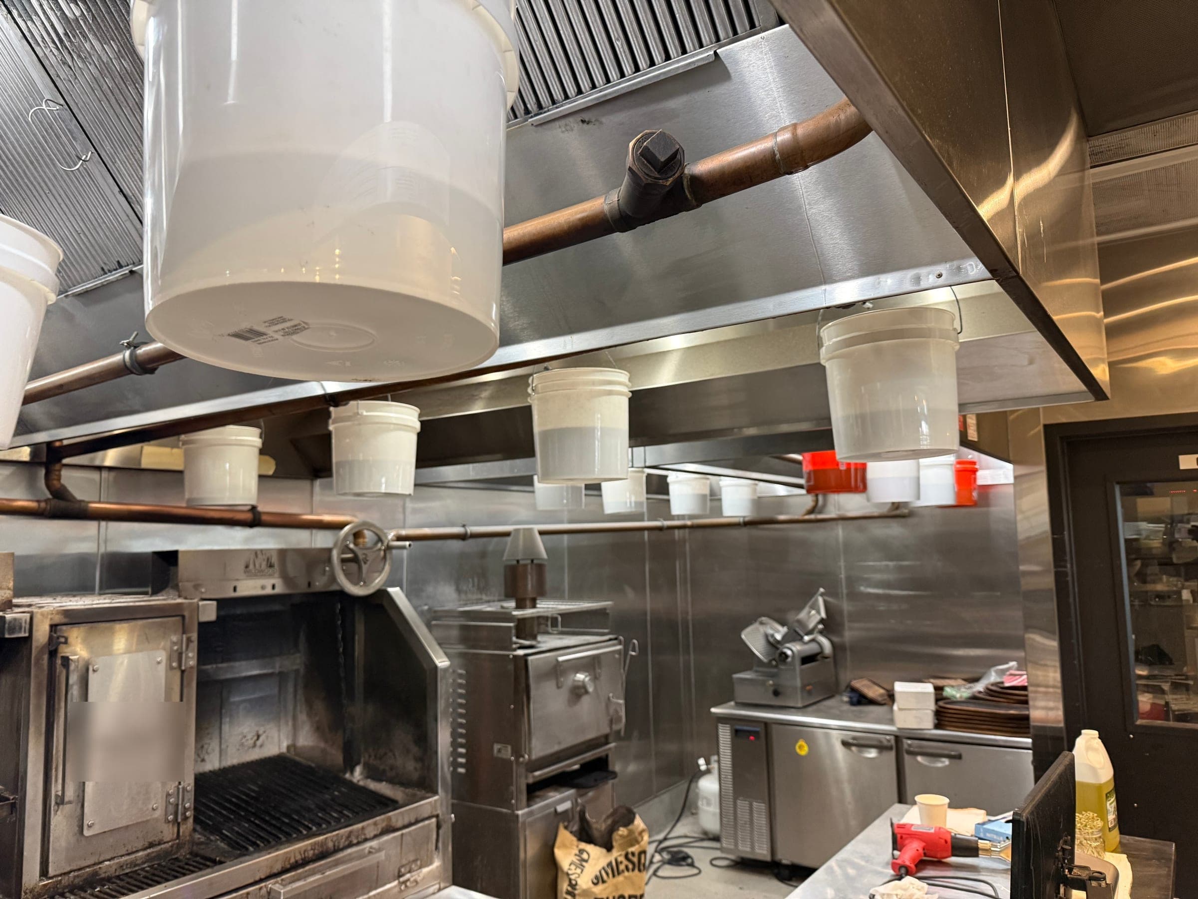 Rows of test buckets hanging beneath the hood and copper piping along the cooking line