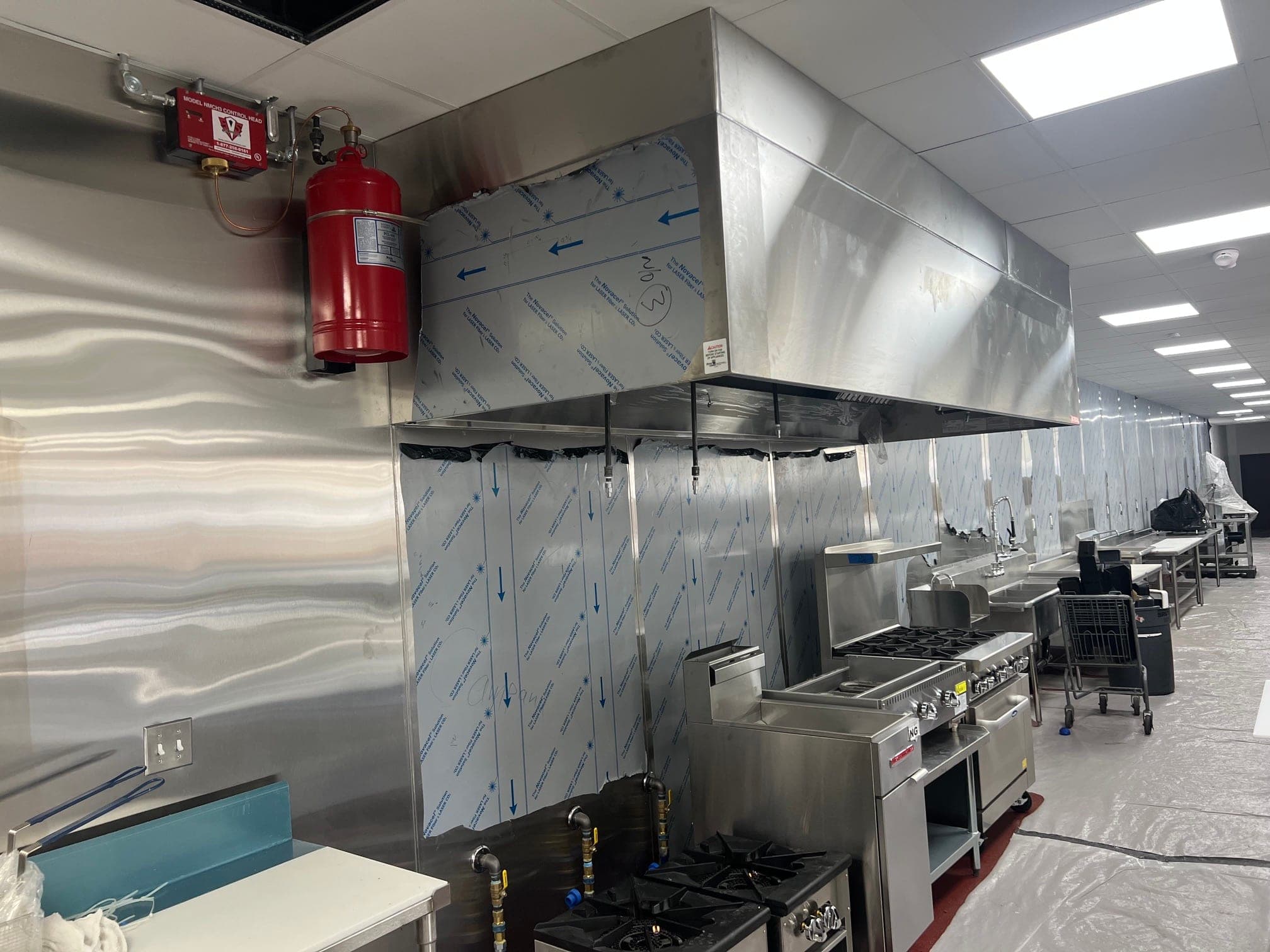 Pyro-Chem PCL-460 cylinder and control head mounted beside a new hood over the cooking line
