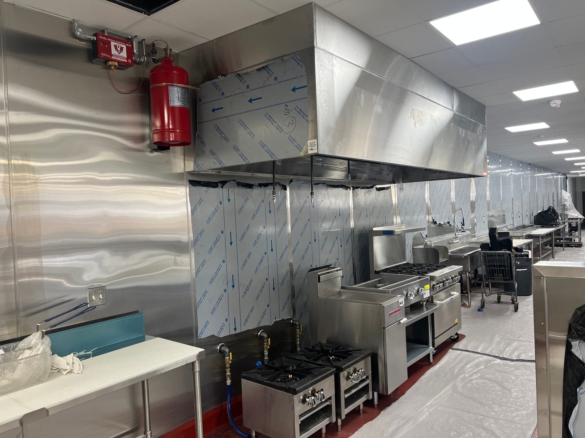Pyro-Chem PCL-460 cylinder and control head on the wall, piping run to nozzles under a new hood