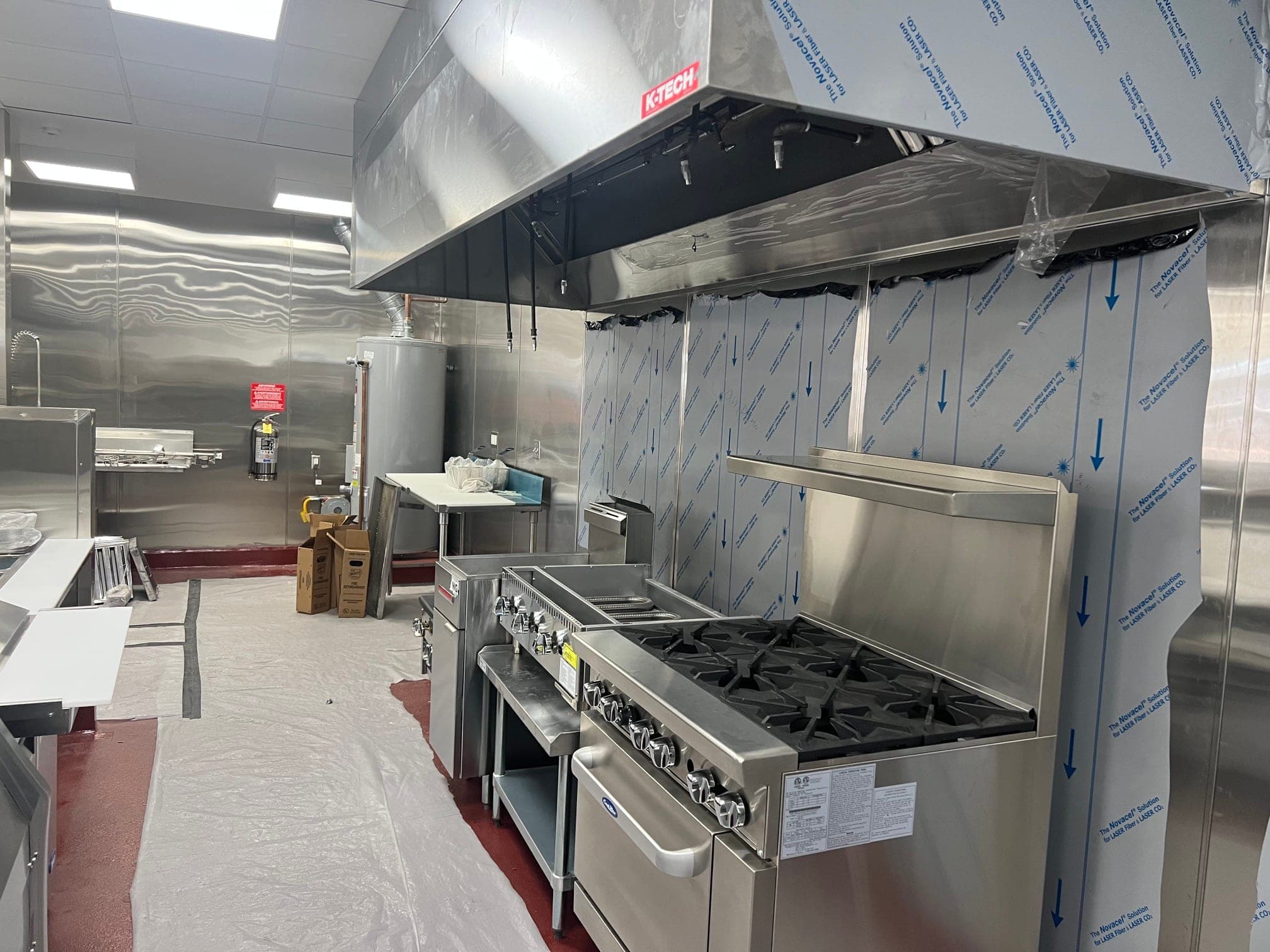 Suppression nozzle drops under the new hood above a range and fryers