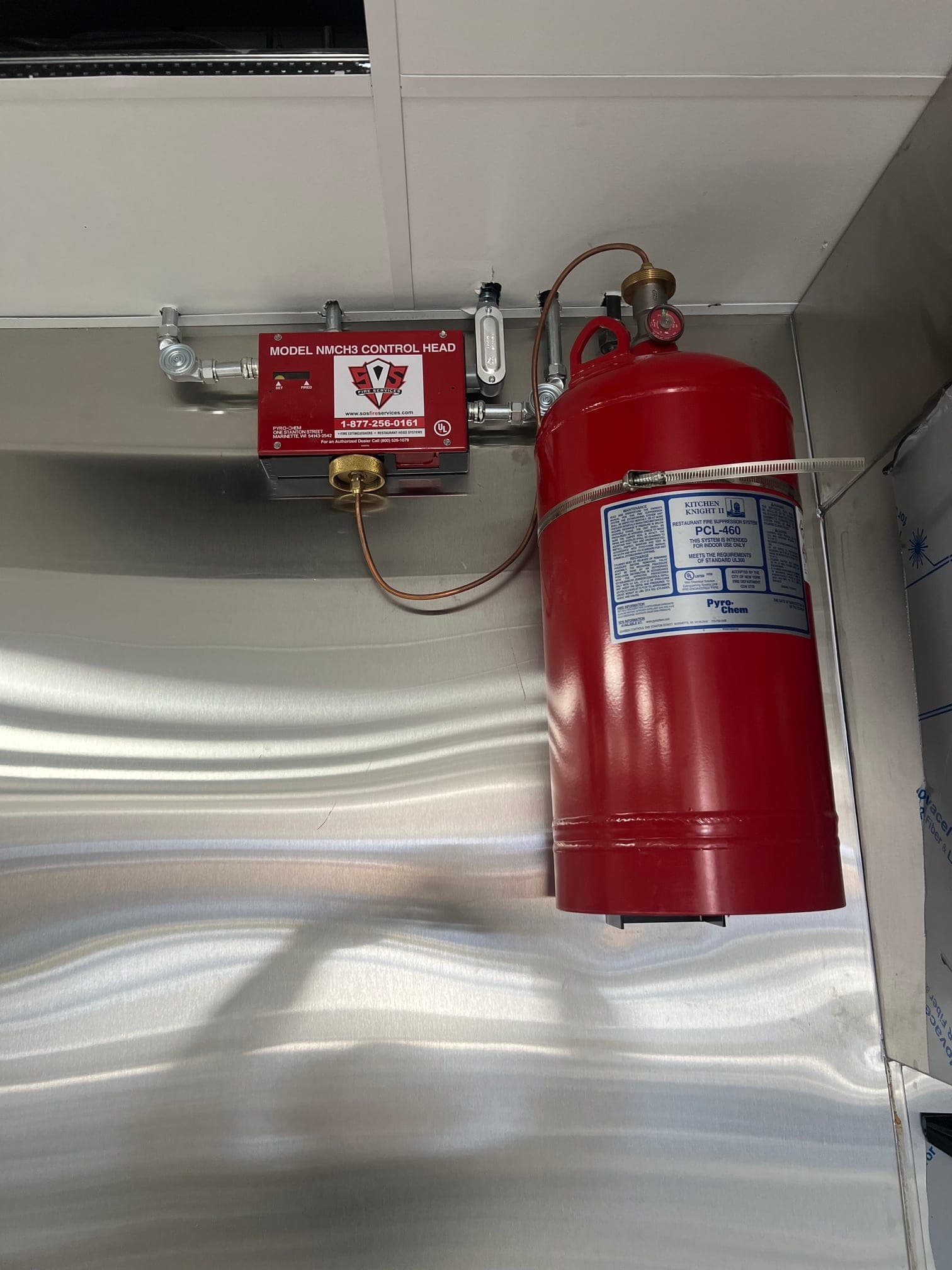 Pyro-Chem PCL-460 cylinder strapped to the wall next to its control head